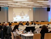 A group of professionals sit around a conference table.